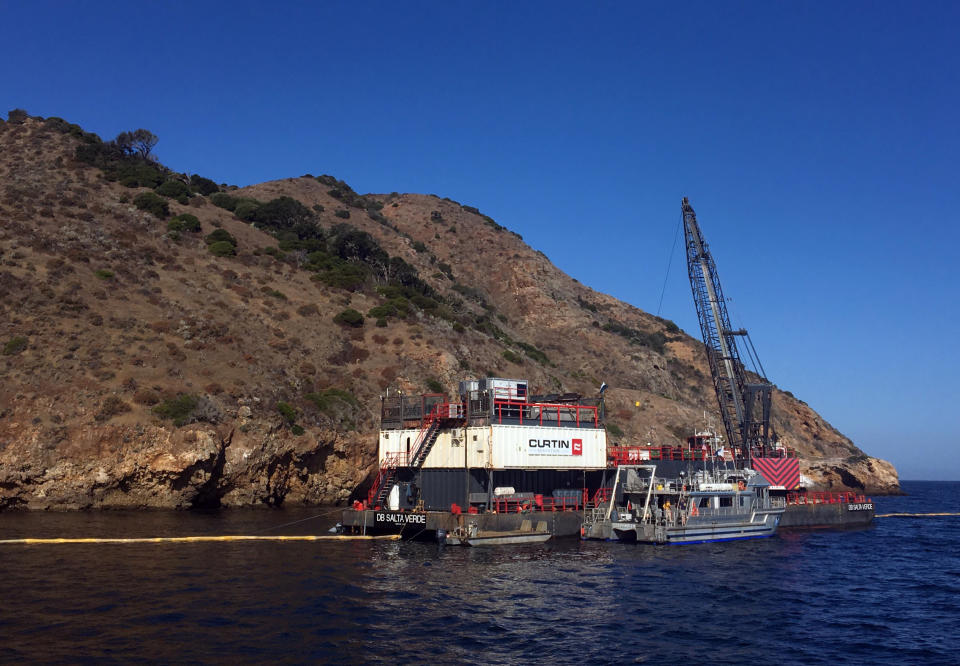 This photo provided by the U.S. Coast Guard shows the derrick barge Salta Verde engaged in salvage operations over the wreck of the dive boat Conception at Santa Cruz Island off the coast of Southern California Friday, Sept. 6, 2019. The Conception burned and sank Sept. 2, taking the lives of 34 people. (U.S. Coast Guard via AP)