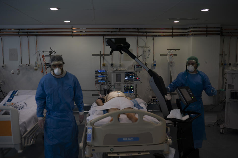 Healthcare workers prepare to x-ray a COVID-19 patient at a library that was turned into an intensive care unit (ICU) at German Trias i Pujol hospital in Badalona, Barcelona province, Spain, Wednesday, April 1, 2020. The new coronavirus causes mild or moderate symptoms for most people, but for some, especially older adults and people with existing health problems, it can cause more severe illness or death. (AP Photo/Felipe Dana)