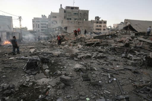 Members of a Palestinian civil defence team search through the rubble of a building destroyed in an Israeli air strike on Gaza City on October 27, 2018