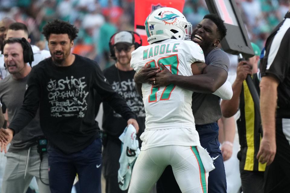 Dolphins receiver Tyreek Hill hugs Jaylen Waddle after Waddle scored against the Jets.
