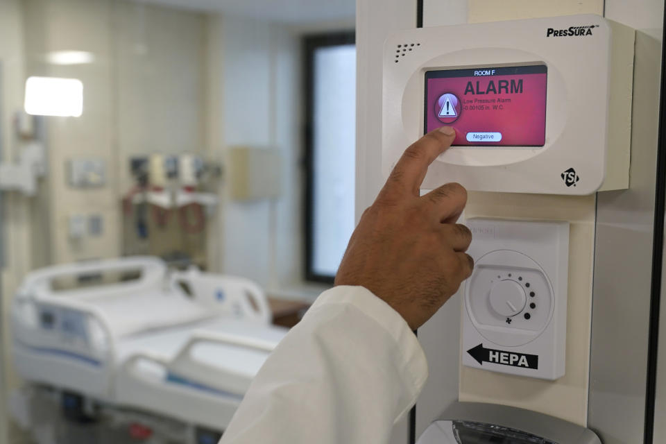 Dr. Amit Uppal, Director of Critical Care at Bellevue, demonstrates new equipment that makes a normal room into an isolation room at Bellevue Hospital in New York, Wednesday, Oct. 28, 2020. The rooms in this area have been outfitted to care for COVID-19 patients if there is a surge that overwhelms their usual critical care facilities. Hospitals in the city's public NYC Health and Hospitals' system have been upgrading their equipment, bracing for a potential resurgence of coronavirus patients, drawing on lessons learned in the spring when the outbreak brought the nation's largest city to its knees. (AP Photo/Seth Wenig)