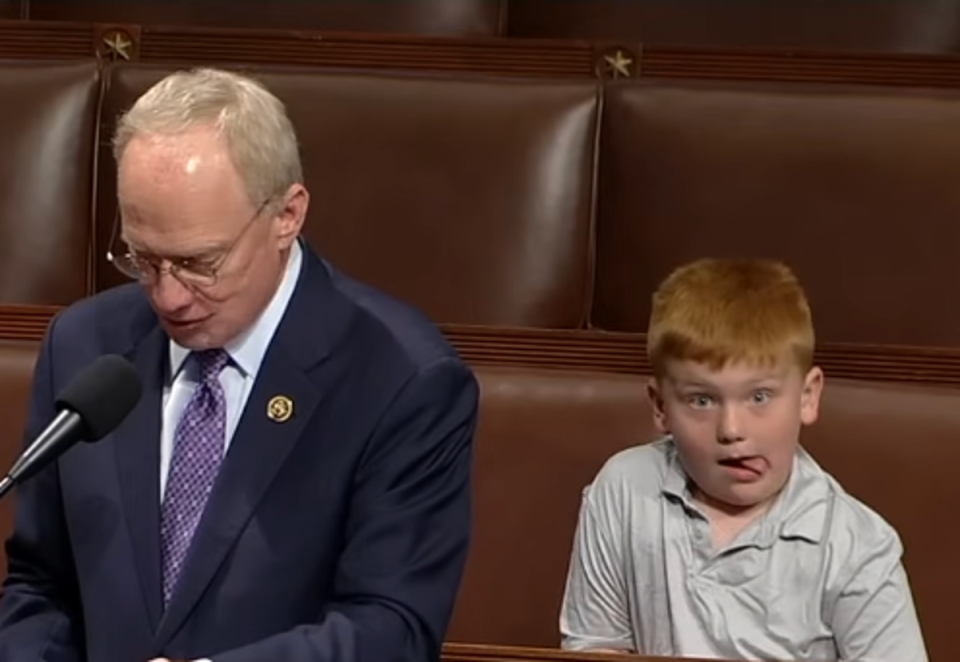 Representative John Rose (R-Tenn.) gives a speech on June 3, 2024, at the House of Representatives, while his son Guy makes funny faces behind him (C-Span)