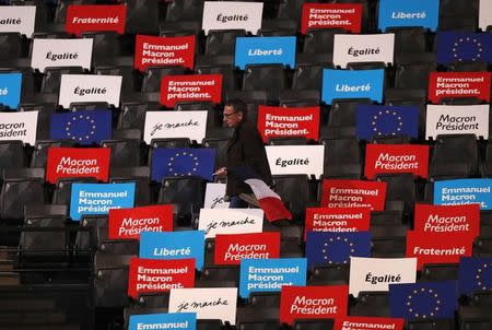 A supporter holds a French flag as he enters the AccorHotels Arena to attend a political rally for Emmanuel Macron, head of the political movement En Marche !, or Onwards !, and candidate for the 2017 French presidential election, in Paris, France, April 17, 2017. REUTERS/Christian Hartmann