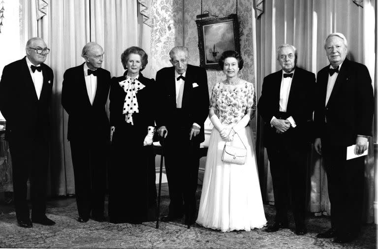 La reina Isabel II de Gran Bretaña, en el centro a la derecha, y la primera ministra Margaret Thatcher, en el centro a la izquierda, posan con los ex primeros ministros británicos en una cena en el número 10 de Downing Street de Londres, el 4 de diciembre de 1985