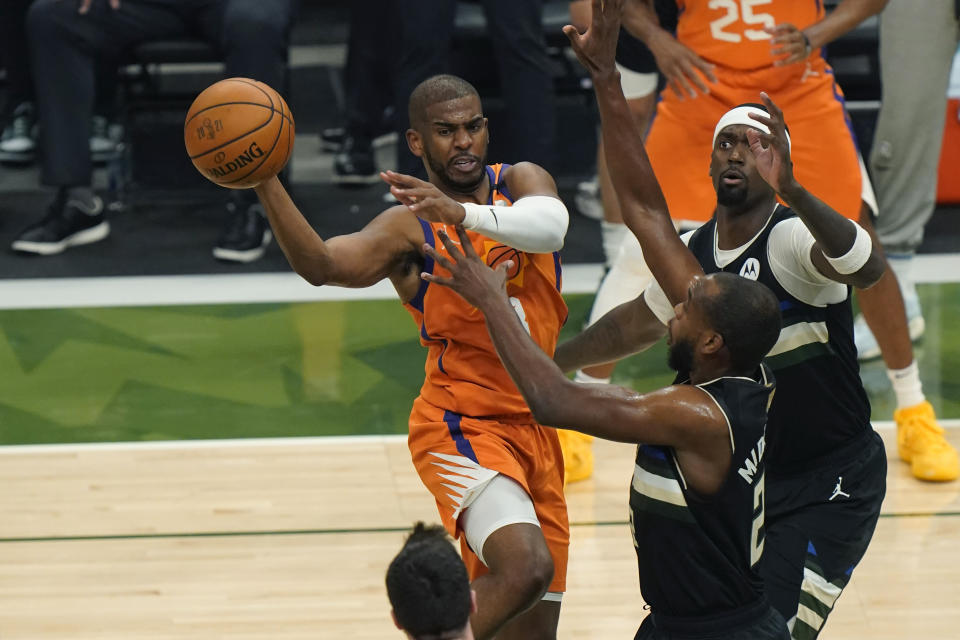 Phoenix Suns guard Chris Paul tries to pass around Milwaukee Bucks forward Khris Middleton during the first half of Game 6 of basketball's NBA Finals in Milwaukee, Tuesday, July 20, 2021. (AP Photo/Paul Sancya)