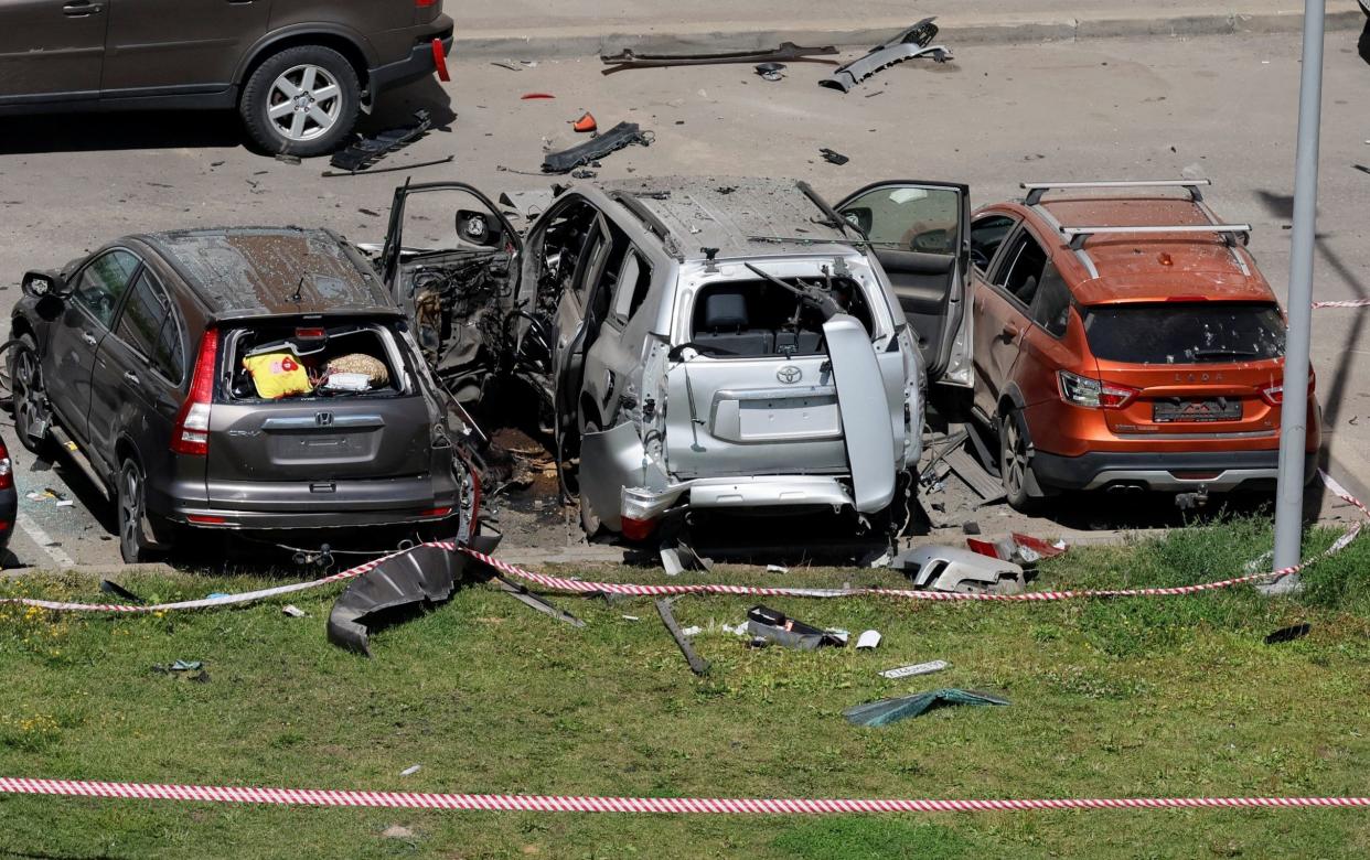 A view shows damaged cars, including a Toyota Land Cruiser, following an explosion caused by the detonation of an unidentified device