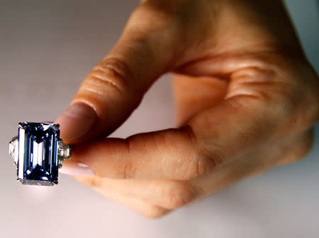 A Christie's employee poses with the 14.62 carats Oppenheimer Blue diamond during a preview in Geneva, Switzerland May 12, 2016. REUTERS/Denis Balibouse/File Photo