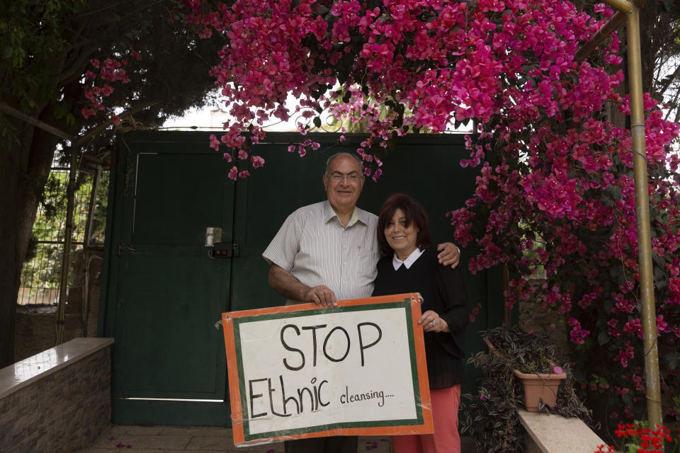 Samira Dajani and her husband, Adel Budeiri, pose for a portrait in the garden of their home, where she has lived since childhood, in the Sheikh Jarrah neighborhood of east Jerusalem, Sunday, May 9, 2021. The Dajanis are one of several Palestinian families facing imminent eviction from the neighborhood following a decades-long legal battle. The families' plight has ignited weeks of demonstrations and clashes in recent days between protesters and Israeli police. (AP Photo/Maya Alleruzzo)