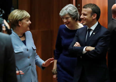 German Chancellor Angela Merkel (L) British Prime Minister Theresa May (C) and French President Emmanuel Macron arrive at a EU summit in Brussels, Belgium October 19, 2017. REUTERS/Yves Herman