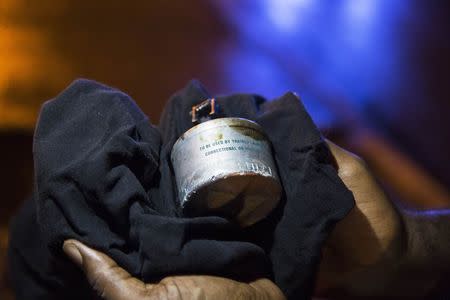 A man holds a tear gas canister fired by police officers during a demonstration to protest against the shooting of Michael Brown in Ferguson, Missouri, August 16, 2014. REUTERS/Lucas Jackson