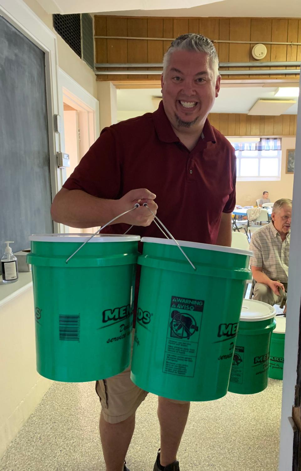 Dale Bicker lifts a few of the Flood Buckets Jeromesville Lutheran Church packed to send to Iowa for disaster relief.