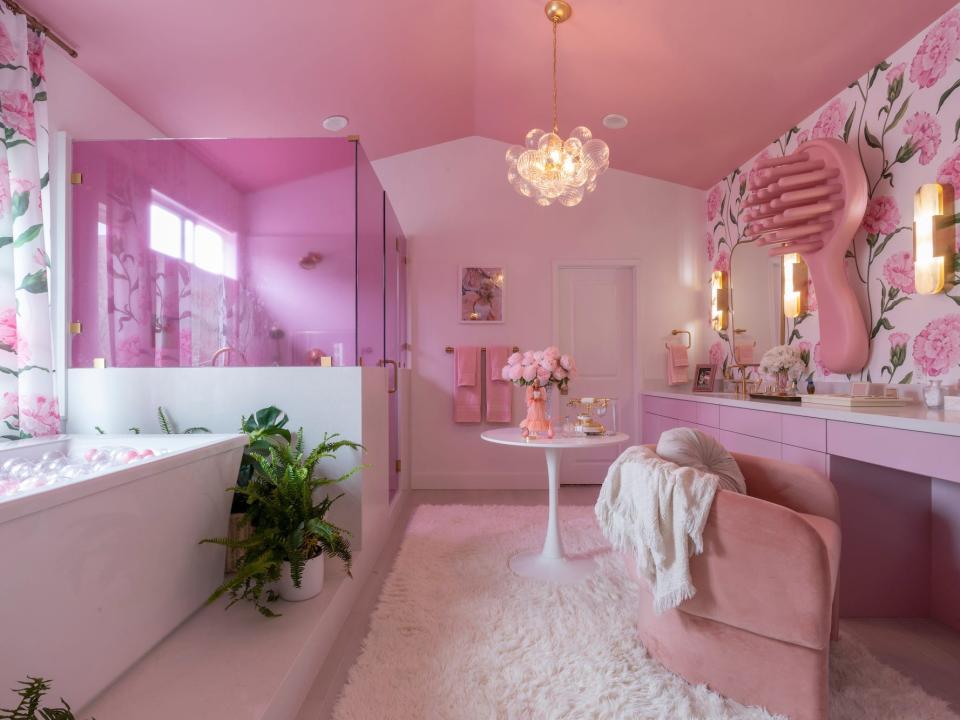 A pink bathroom with a large tub and shower.