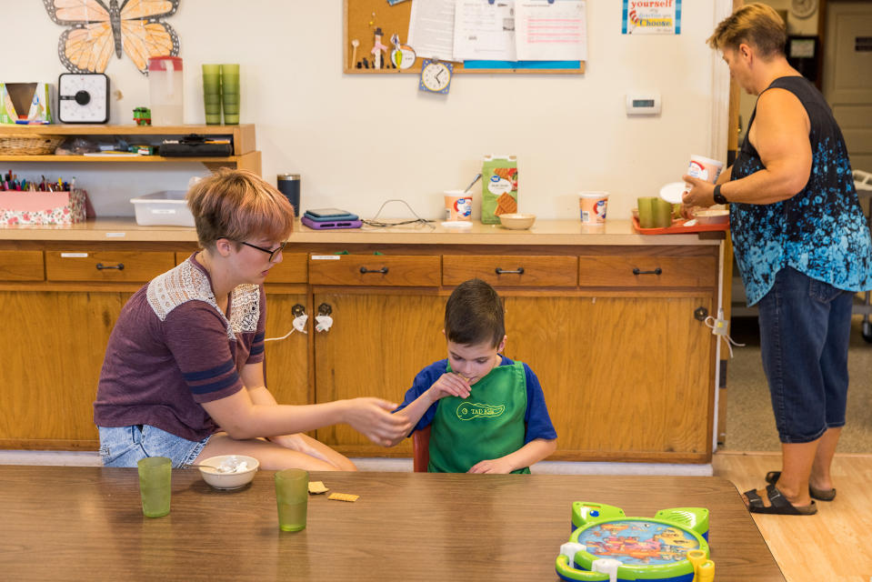 Corrine VanderGaast, Deborah's daughter and an assistant teacher at the daycare, helps Dircks Grau, age 9.<span class="copyright">Kathryn Gamble for TIME</span>