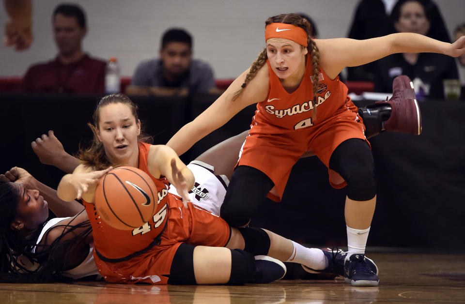 FILE — In this Dec. 21, 2017, file photo, Syracuse forward Digna Strautmane, center, and guard Tiana Mangakahia, right, chase the ball next to a Mississippi State player during the first half of an NCAA college basketball game, in Las Vegas. In spite of everything that's been thrown her way, the smile of Syracuse point guard Tiana Mangakahia and her effervescent persona remain as infectious as ever in the waning weeks of her final season in college. It's in her DNA. (AP Photo/David Becker, File)