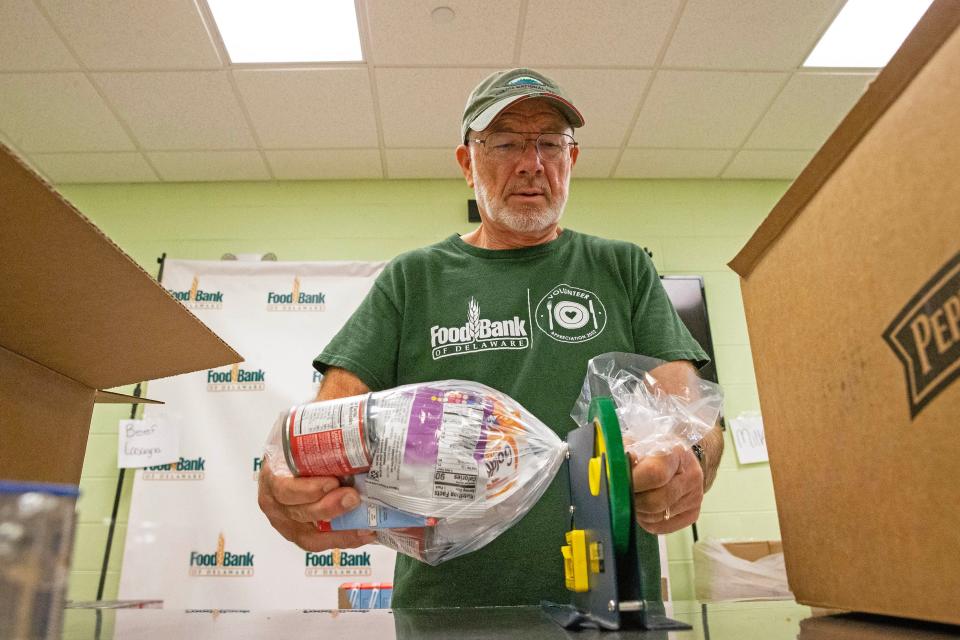 Phil Williamson, a volunteer for 12 years at the Food Bank of Delaware, seals a product bag at the Food Bank in Milford, Thursday, Nov. 9, 2023.