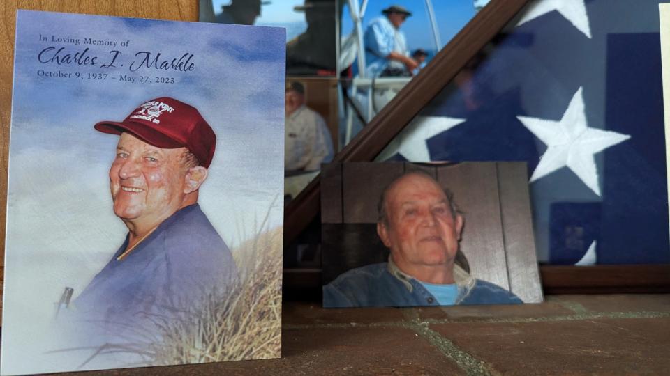 A funeral card for Charles Markle sits on a table with memories and a memorial flag at his former home in York. 
