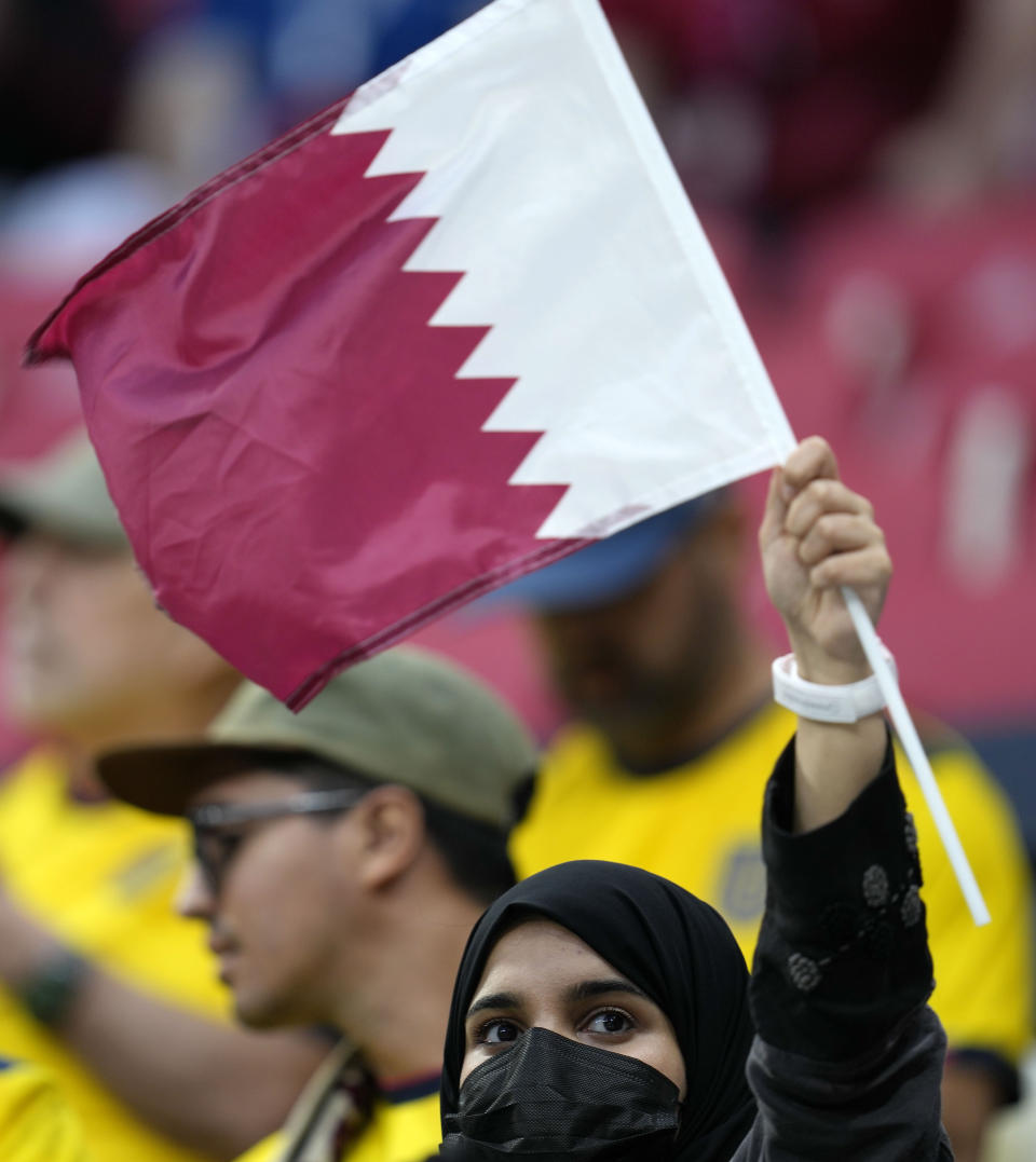 A fan for Qatar waves a flag prior the World Cup, group A soccer match between Qatar and Ecuador at the Al Bayt Stadium in Doha, Sunday, Nov. 20, 2022. (AP Photo/Natacha Pisarenko)