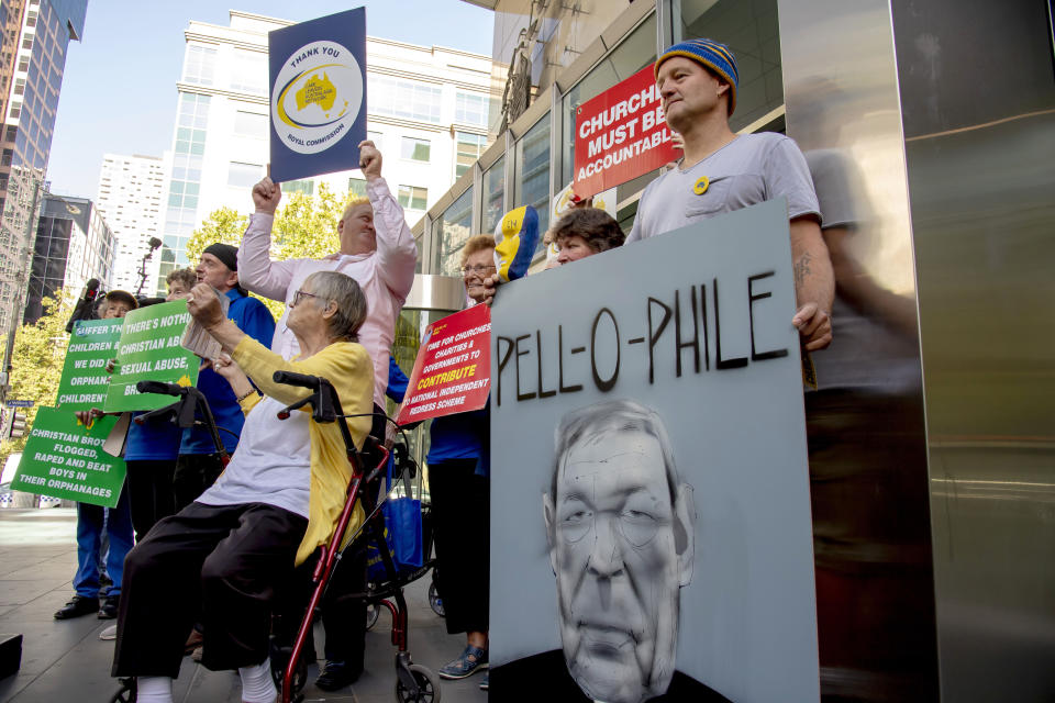 Protesters hold placards outside the County Court where Cardinal George Pell is to arrive in Melbourne, Australia, Wednesday, Feb. 27, 2019. The most senior Catholic cleric ever convicted of child sex abuse faces his first night in custody following a sentencing hearing on Wednesday that will decide his punishment for molesting two choirboys in a Melbourne cathedral two decades ago. (AP Photo/Andy Brownbill)