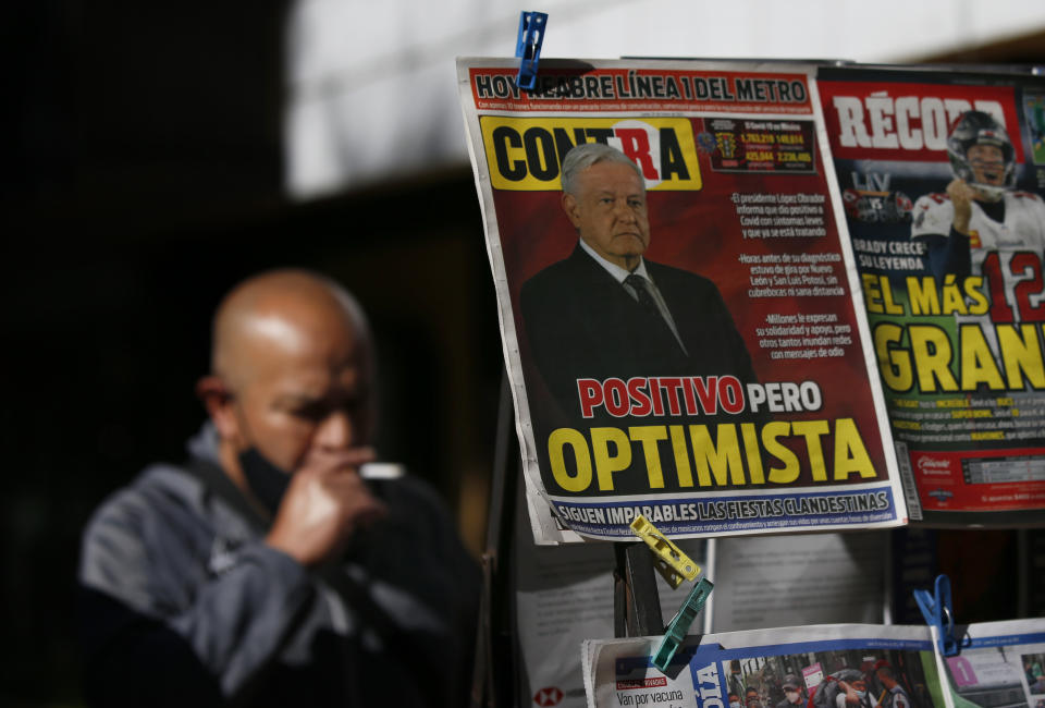 A newspaper's front page carries the Spanish headline "Positive but optimistic" for the story about Mexican President Andrés Manuel López Obrador having COVID-19 at a kiosk on Paseo de la Reforma in Mexico City, Monday, Jan. 25, 2021. López Obrador was working from isolation on Monday, Jan. 25, 2021, a day after announcing that he had tested positive for COVID-19, his interior secretary said. (AP Photo/Marco Ugarte)