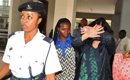 Yang Feng Glan (R), who is suspected of trafficking ivory, covers her face as she leaves the Kisutu Residents Magistrate Court in Dar es Salaam, Tanzania, October 7, 2015. REUTERS/Stringer