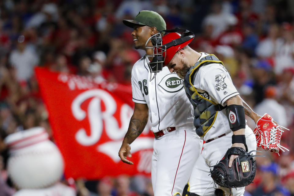 Cincinnati Reds relief pitcher Raisel Iglesias (26) celebrates with catcher Tucker Barnhart, right, after closing the ninth inning of a baseball game against the Chicago Cubs, Friday, Aug. 9, 2019, in Cincinnati. (AP Photo/John Minchillo)