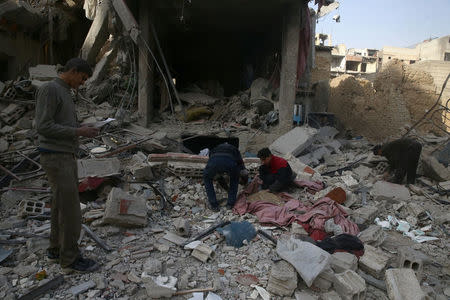 People search for belongings at a damaged site after an airstrike in the besieged town of Douma, Eastern Ghouta, Damascus, Syria February 9, 2018. REUTERS/Bassam Khabieh