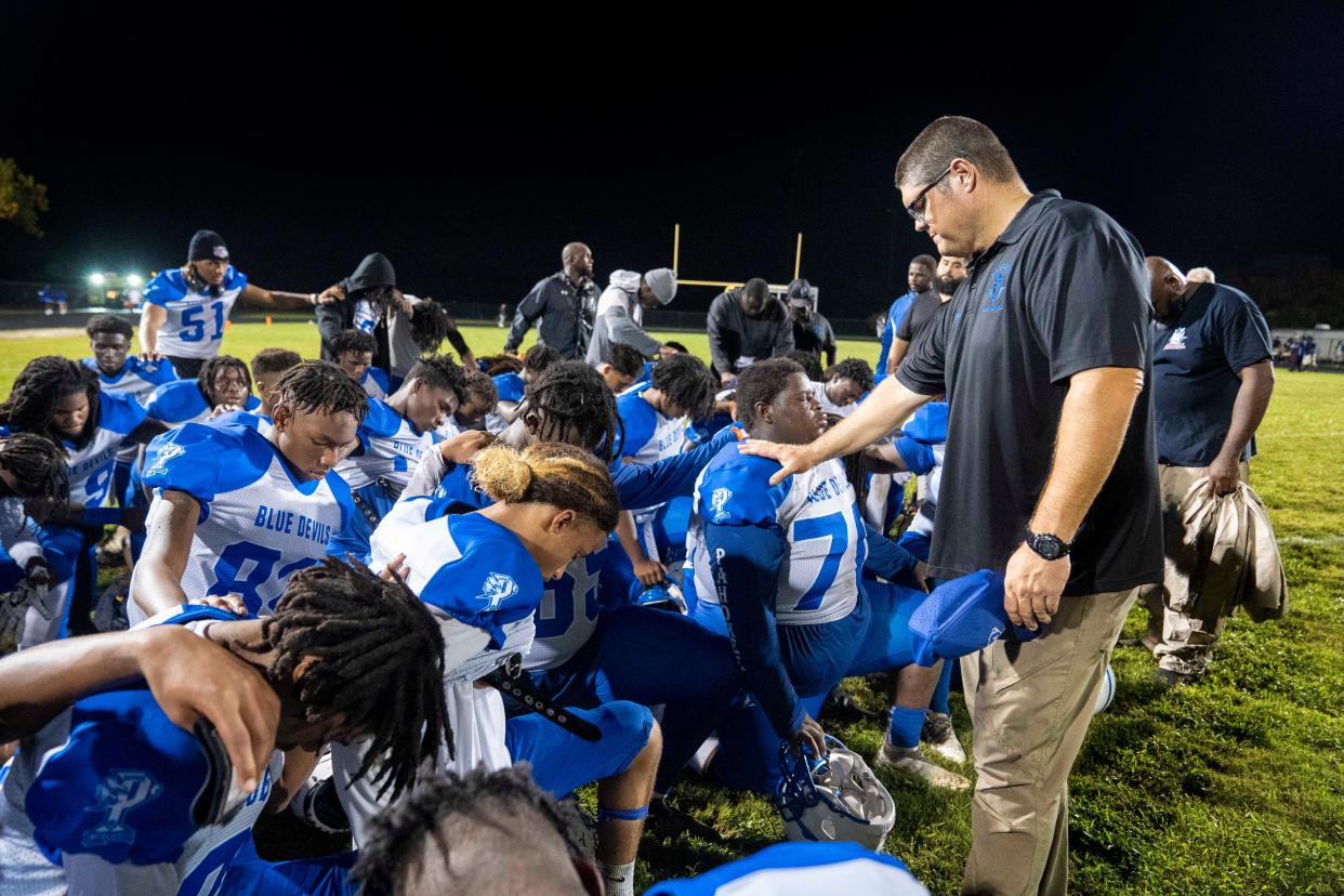 Pahokee  Head Football Coach Matthew Sparrowhawk prays with his team after their 27-13 win over Dwyer High School in Palm Beach Gardens, Florida on September 29, 2023.