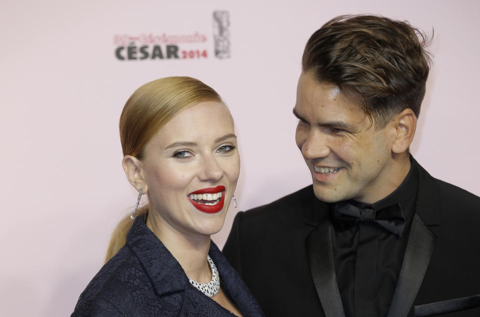 U.S. actress Scarlett Johansson, left, and her partner Romain Dauriac arrive at the 39th French Cesar Awards Ceremony, in Paris, Friday, Feb. 28, 2014. This annual ceremony is presented by the French Academy of Cinema Arts and Techniques. (AP Photo/Lionel Cironneau)