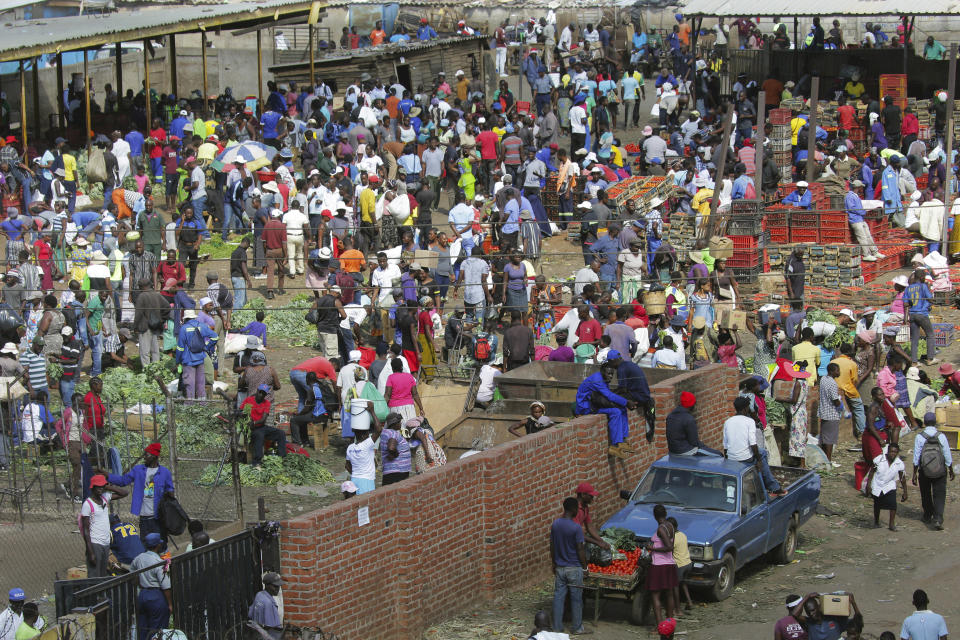 Hundreds of people buy goods at a fruit and vegetable market, despite a lockdown in an effort to curb the spread of the coronavirus, in Harare, Zimbabwe, Tuesday April 7, 2020. (AP Photo/Tsvangirayi Mukwazhi)