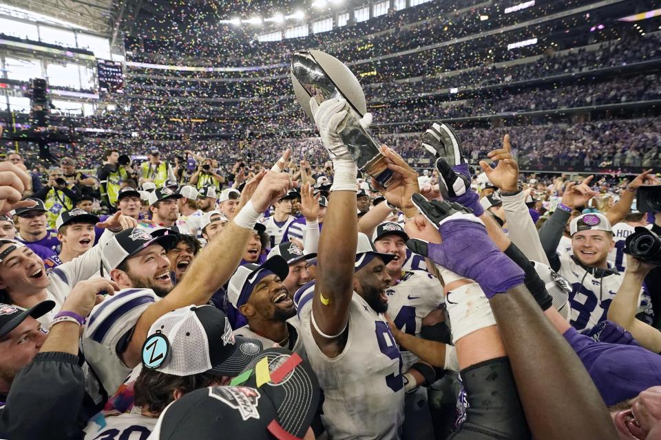 Kansas State players celebrate with the trophy after winning the Big 12 Conference championship NCAA college football game against TCU, Saturday, Dec. 3, 2022, in Arlington, Texas. (AP Photo/LM Otero)