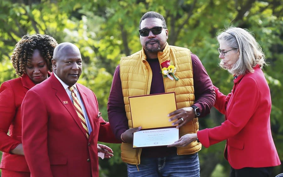 Iowa State University President Wendy Wintersteen, right, and Jeff Johnson, president of the ISU alumni assocation, present Jack Trice’s posthumous degree to his cousin George Trice, center, Sunday, Oct. 8, 2023, in Ames, Iowa. (Nirmalendu Majumdar/Ames Tribune via AP)