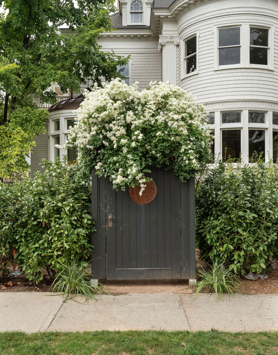 The exterior of the home features a flower-covered gate.