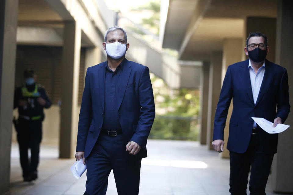 Pictured are Victoria Chief Health Officer Brett Sutton and Victorian Premier Daniel Andrews walking to a briefing wearing face masks.