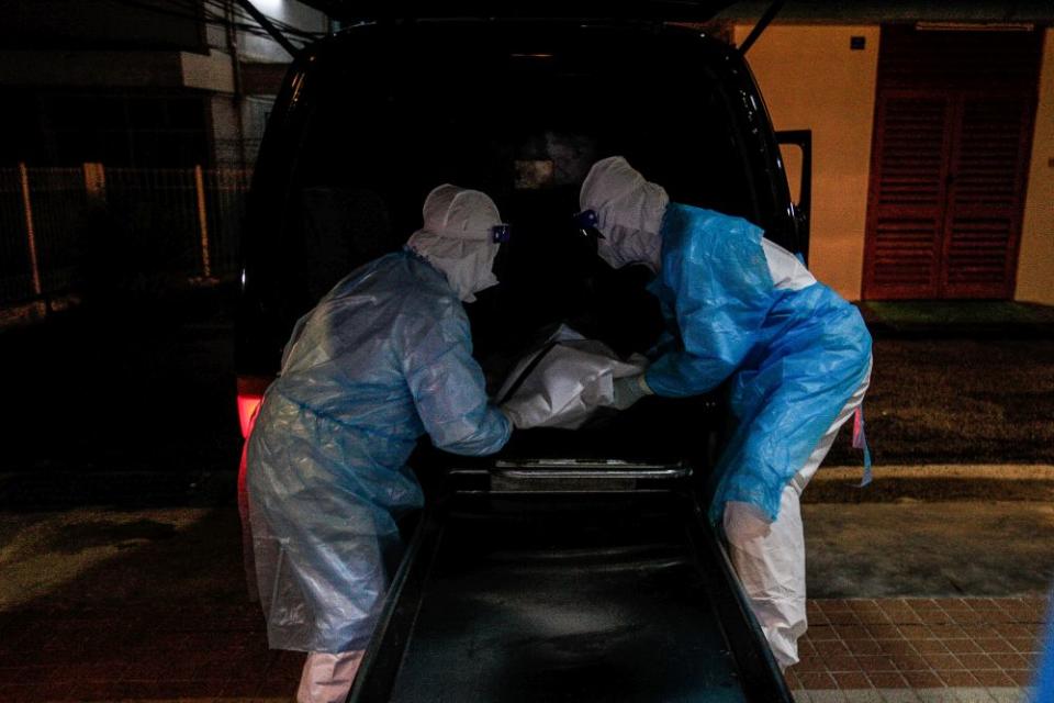 Forensics personnel unload the body of a recently deceased Covid-19 patient at the Penang General Hospital, August 24, 2021. — Picture by Sayuti Zainudin