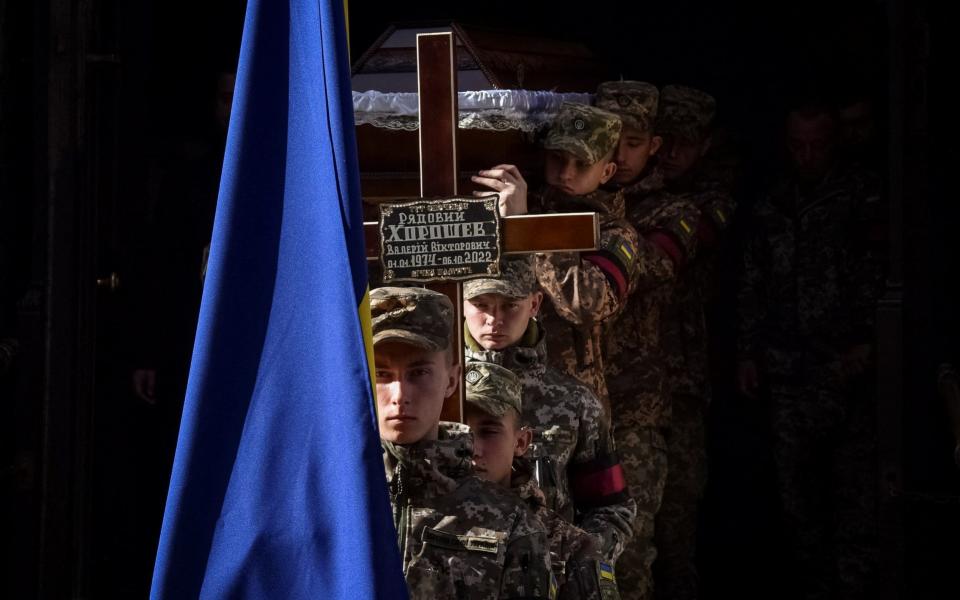 Ukrainian servicemen carry a coffin during a funeral ceremony for their brother-in-arms Valerii Khoroshev in Lviv - PAVLO PALAMARCHUK/REUTERS