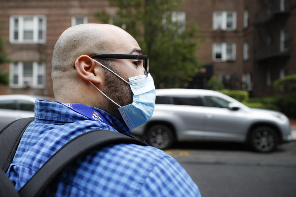 Joseph Ortiz, a contact tracer with New York City Health + Hospitals, heads to a potential COVID-19 patient's home Thursday, Aug. 6, 2020, in New York. The city has hired more than 3,000 tracers and the city says it's now meeting its goal of reaching about 90% of all newly diagnosed people and completing interviews with 75%. (AP Photo/John Minchillo)