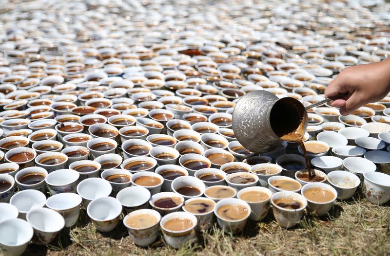 A volunteer prepares the installation of some 8,000 traditional porcelain cups filled with Bosnian coffee at the Potocari-Srebrenica Memorial Centre for victims of the 1995 massacre of some 8,000 Muslim men and boys