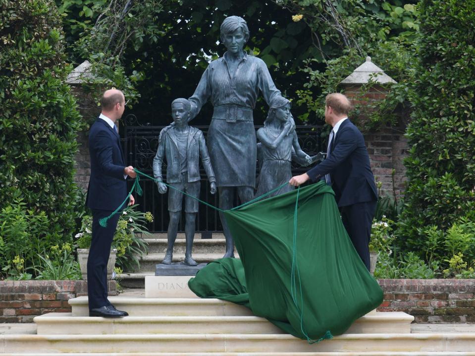 Prince Harry and Prince William pull back a covering to reveal the statue of their mother, Princess Diana, on what would have been her 60th birthday.