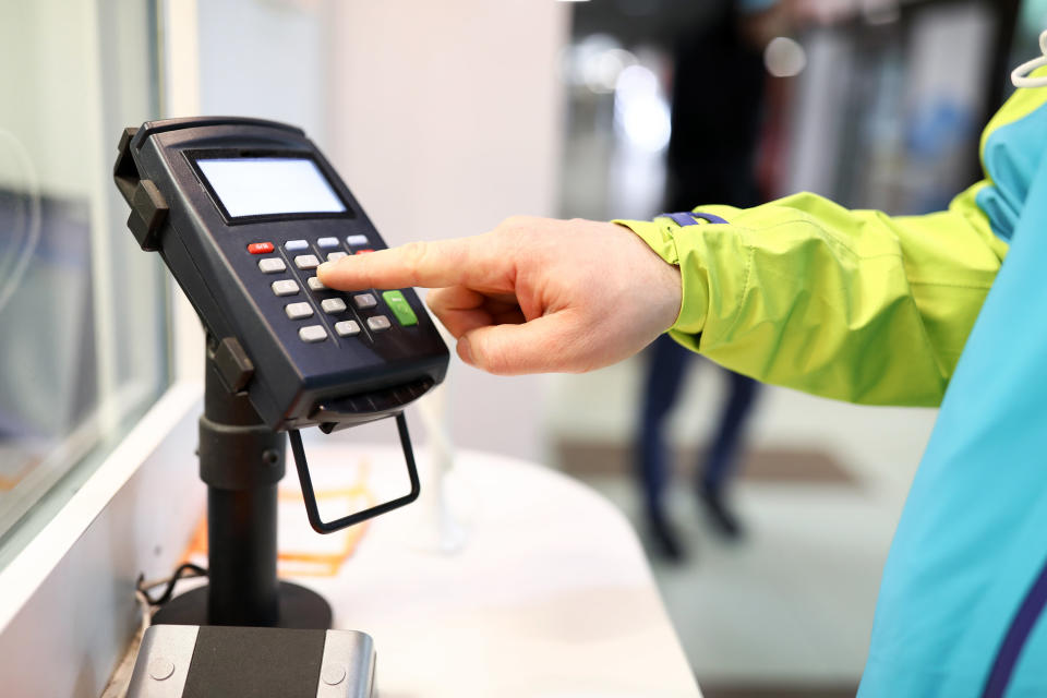 Person touching a pinpad with his finger