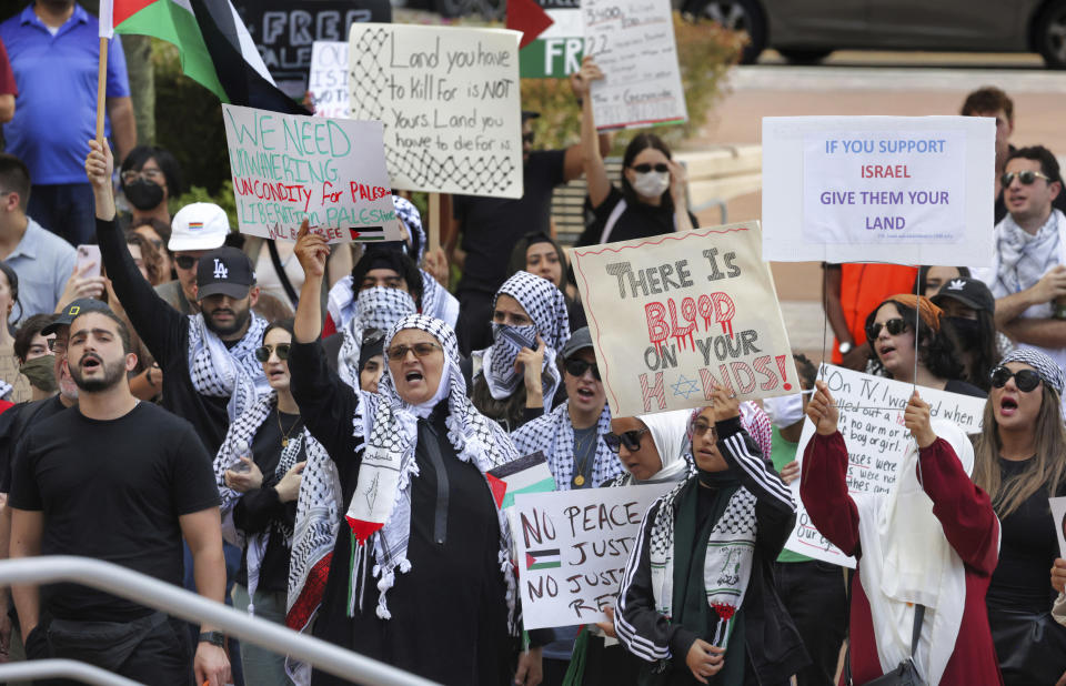 FILE - Pro-Palestinian supporters hold up signs during a demonstration at Orlando City Hall, Friday, Oct. 20, 2023, in Orlando, Fla. State lawmakers across the country are expected consider legislation related to the Israel-Hamas war in 2024. (Joe Burbank/Orlando Sentinel via AP, File)