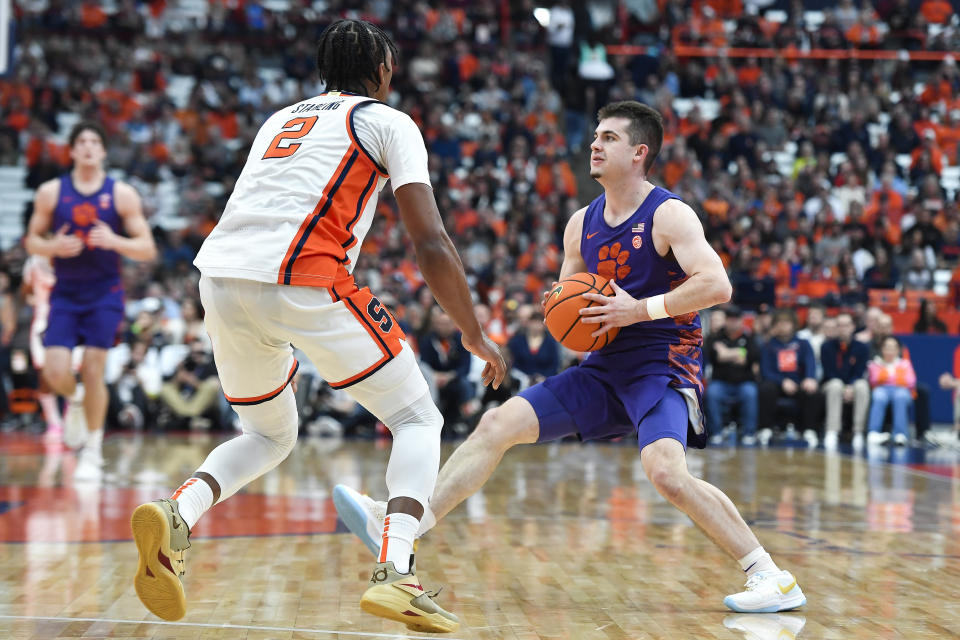 Clemson guard Joseph Girard III, right, is defended by Syracuse guard J.J. Starling during the first half of an NCAA college basketball game in Syracuse, N.Y., Saturday, Feb. 10, 2024. (AP Photo/Adrian Kraus)