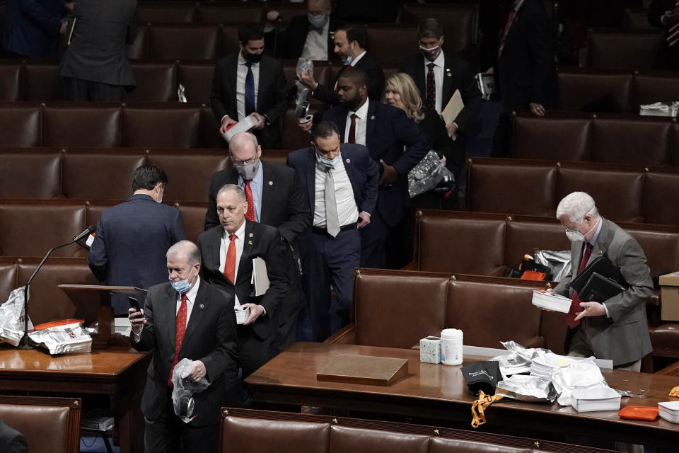 FILE - Members of Congress leave the floor of the House chamber as rioters try to break into the chamber at the U.S. Capitol on Wednesday, Jan. 6, 2021, in Washington. (AP Photo/J. Scott Applewhite, File)