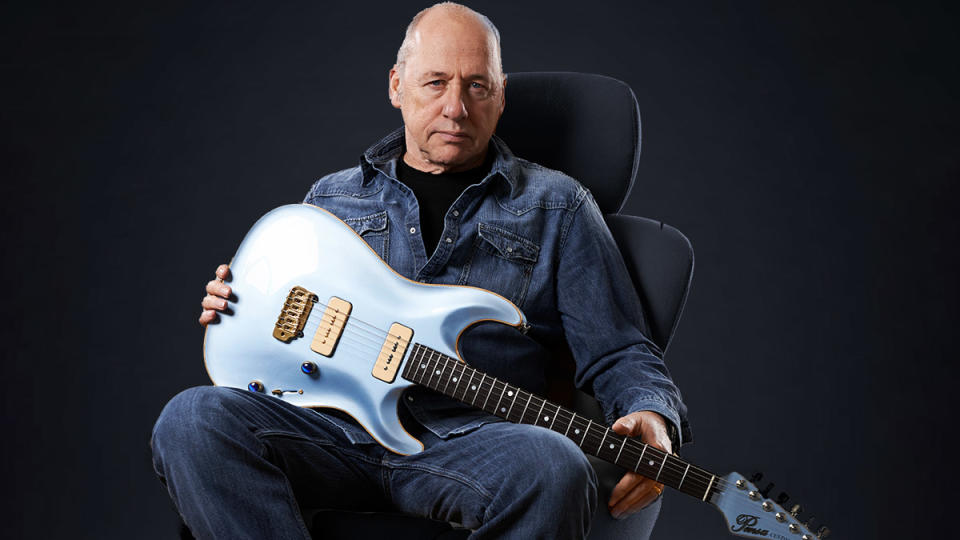 Mark Knopfler, seated with one of his custom Pensa guitars