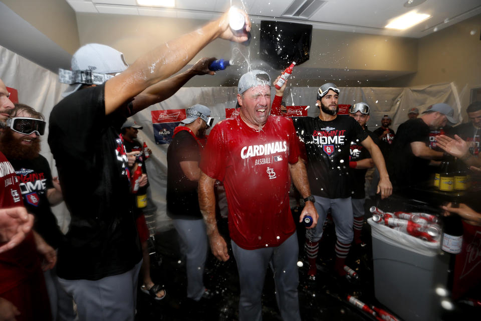 St. Louis Cardinals bullpen coach Bryan Eversgerd, center, is doused with beer as players celebrate in the clubhouse after the Cardinals beat the Atlanta Braves 13-1 in Game 5 of their National League Division Series baseball game Wednesday, Oct. 9, 2019, in Atlanta. (AP Photo/John Bazemore)