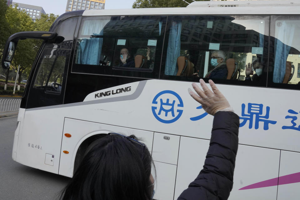 Workers wave to the team of experts from the World Health Organization who ended their quarantine and left the quarantine hotel in a bus in Wuhan in central China's Hubei province on Thursday, Jan. 28, 2021. (AP Photo/Ng Han Guan)