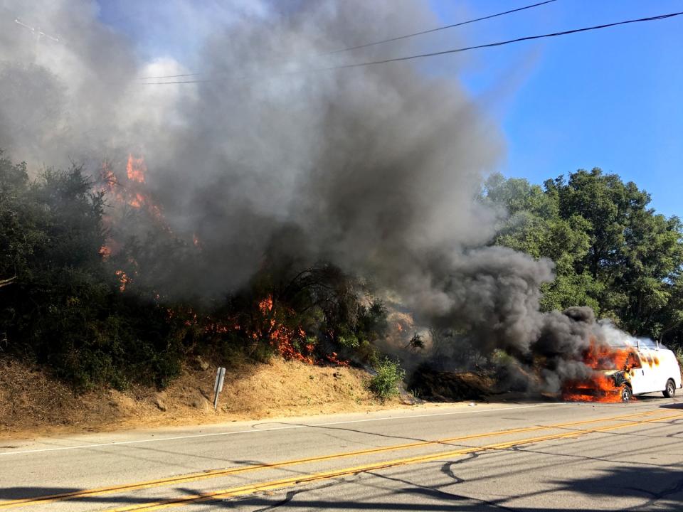 A car on fire ignites brush in Topanga.