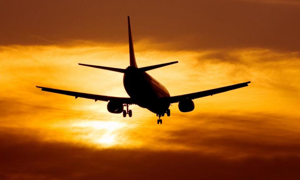 Airplane landing at sunset