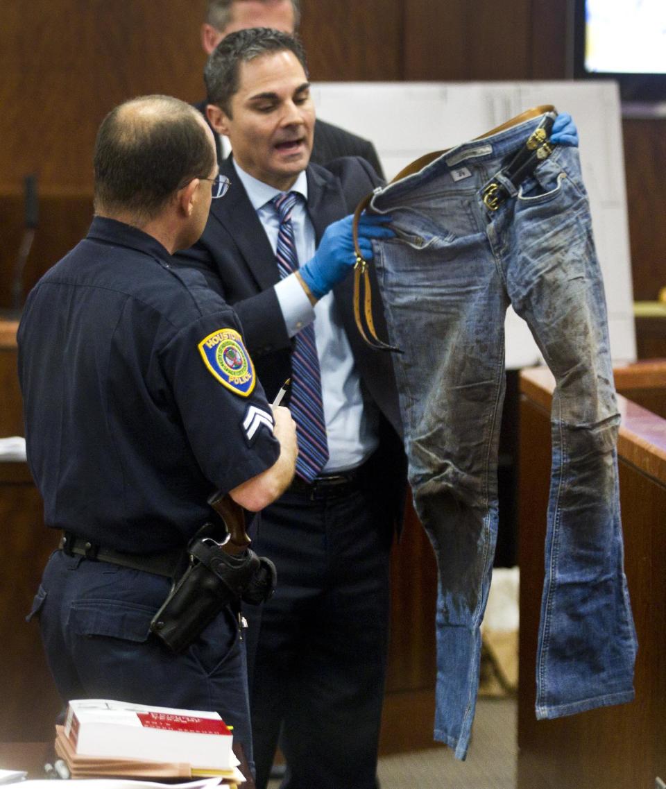 Prosecutor John Jordan holds up a pair of bloody jeans as Houston Police senior officer Chris Duncan testifies during the trial against Ana Lilia Trujillo Tuesday, April 1, 2014, in Houston. Trujillo, 45, is charged with murder, accused of killing her 59-year-old boyfriend, Alf Stefan Andersson with the heel of a stiletto shoe, at his Museum District high-rise condominium in June 2013. (AP Photo/Houston Chronicle, Brett Coomer) MANDATORY CREDIT