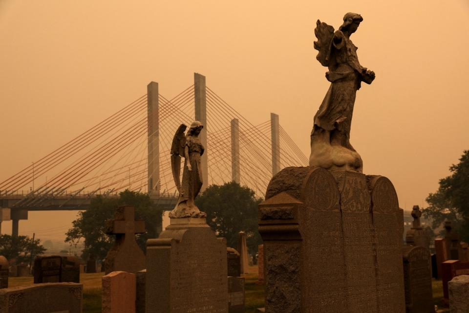 2023年6月7日，美國紐約市皇后區卡瓦利公墓（Calvary Cemetery），暗橘色天空下的天使像更凸顯末日氛圍。路透社