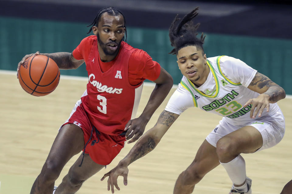 Houston's DeJon Jarreau, left, drives past South Florida's Caleb Murphy during the first half of an NCAA college basketball game Wednesday, Feb. 10, 2021, in Tampa, Fla. (AP Photo/Mike Carlson)